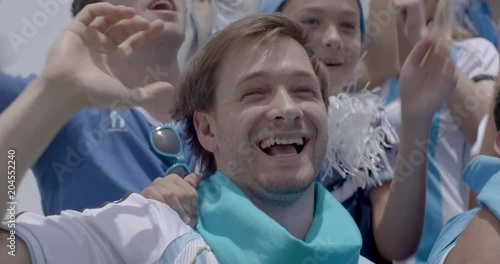 Argentinian football fans jumping and cheering at match, slow motion