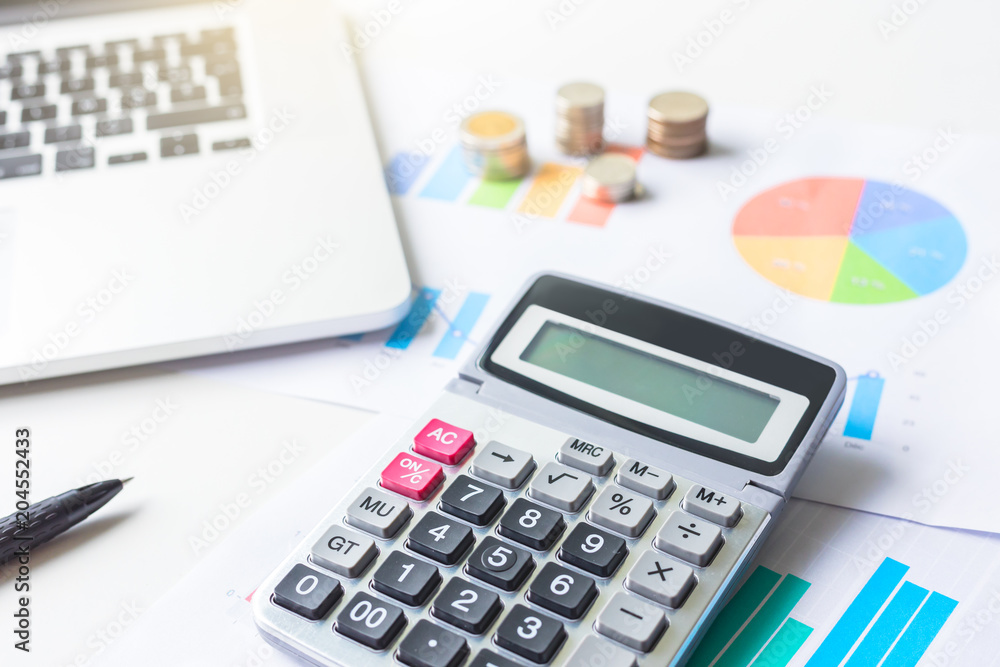 Saving money concept. Financial business graph with laptop and calculator Saving money concept. Financial business graph with laptop and calculator