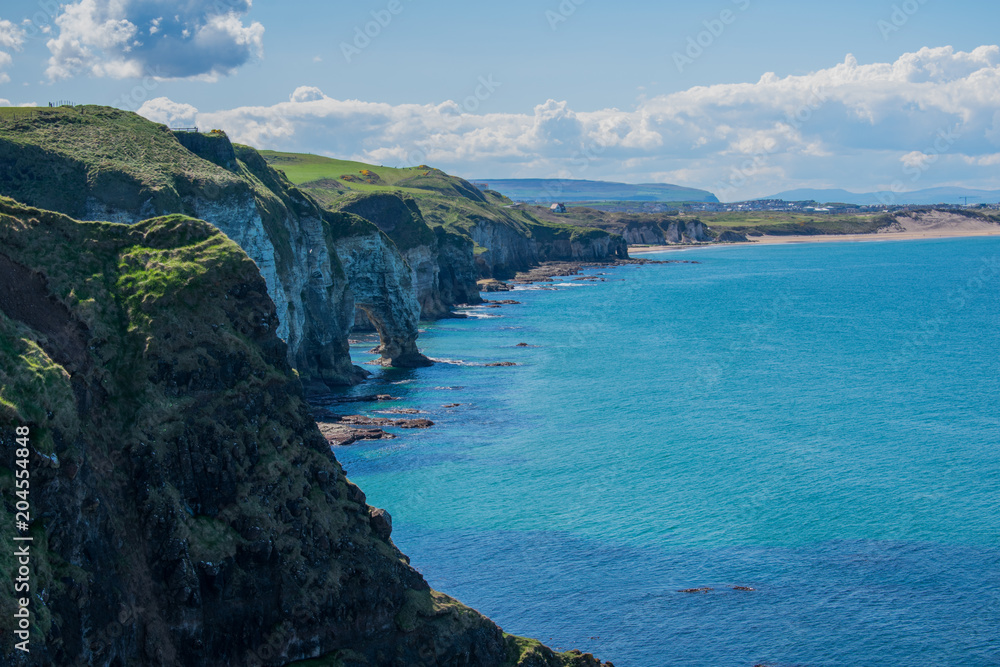 landscape over cliffs and coast of ocean in northern ireland. beautiful view of nature. clear sky and sunny day 