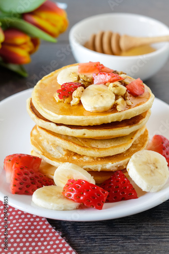 Healthy breakfast table withhomemade pancakes, exotic fruits and coffee