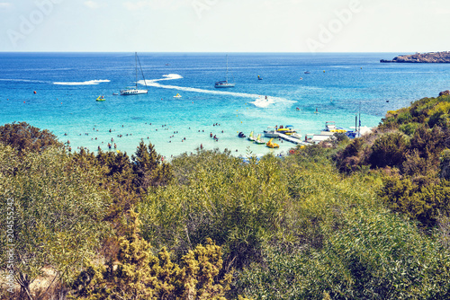 Daylight view from top to Konnos beach with people relaxing