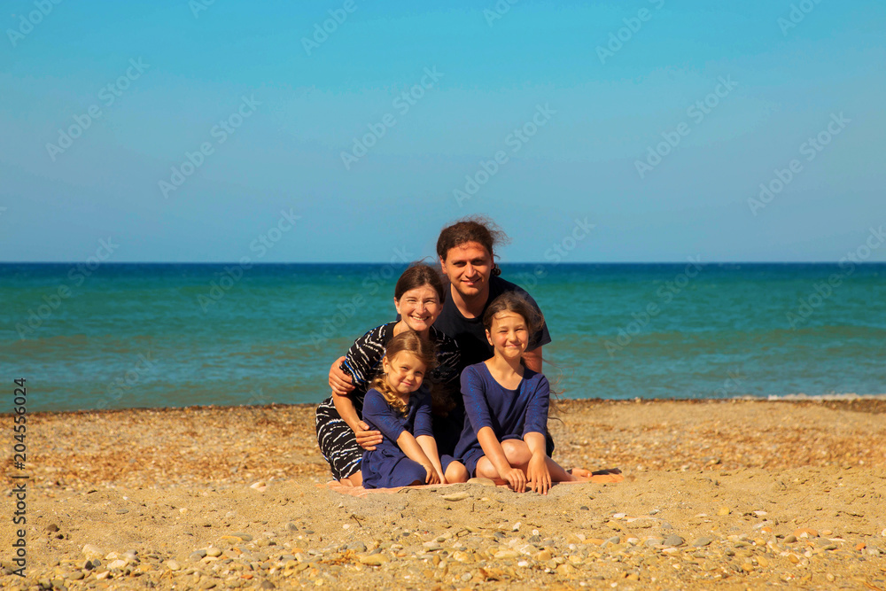 Portrait of smiling family on the beach against the sea. Portrait of smiling family on the beach against the sea.