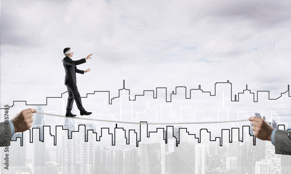 Business concept of risk support and assistance with man balancing on rope Business concept of risk support and assistance with man balancing on rope