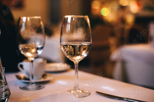 glass in the evening on the table in the restaurant. concept of a lonely date. © velimir