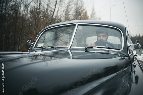Escort man or security guard. Travel and business trip or hitch hiking. Bearded man in car. Call boy in vintage auto. Retro collection car and auto repair by mechanic driver