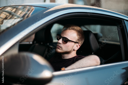 successful young man driving a car. © velimir