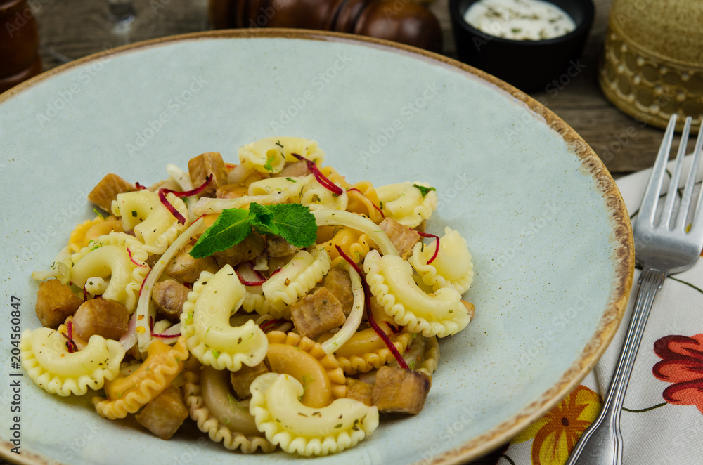 Fried swordfish cubes with fresh vegetables and pasta salad. Fresh salad with fish. Concept healthy food. Fried swordfish cubes with fresh vegetables and pasta salad. Fresh salad with fish. Concept healthy food.