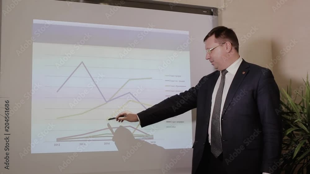 Business report. The man shows a graph of growth indicators.