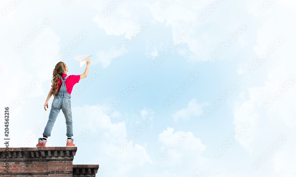 Concept of careless happy childhood with girl dreaming to become pilot Concept of careless happy childhood with girl dreaming to become pilot