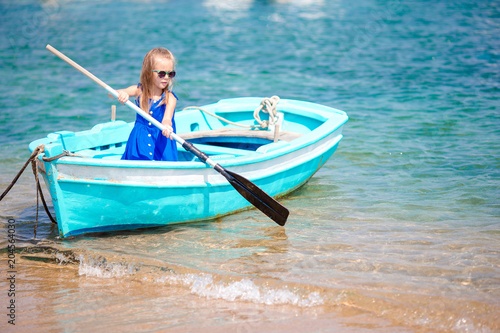 Little girl in blue boat in the sea bay in Greece © travnikovstudio