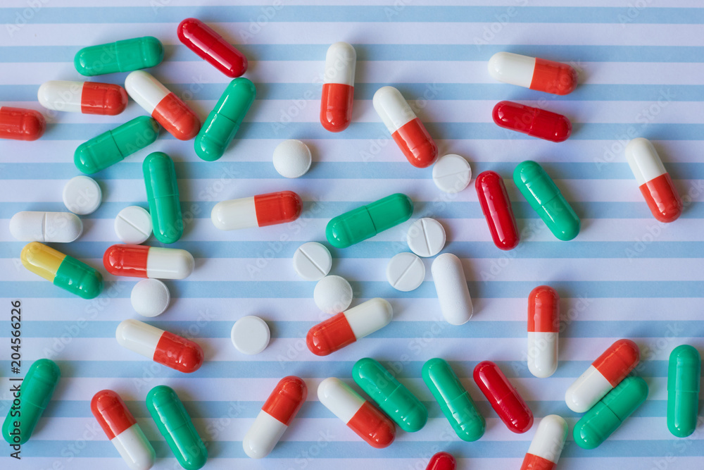 Tablets and pills on a blue medical background. Tablets and pills on a blue medical background.