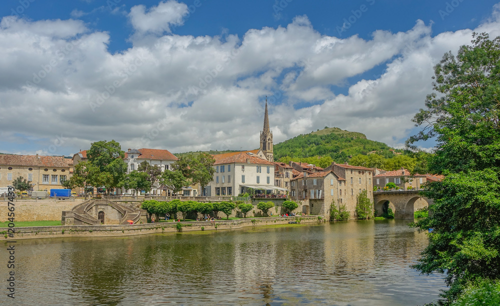 Sant Antonin de Noble Val, Midi Pyrenees, France - July 23, 2017: Panoramic view of the village Sant Antonin de Noble Val with reflections in the river under a blue sky