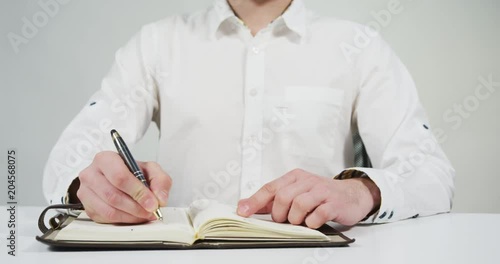 Person writing on an agenda photo