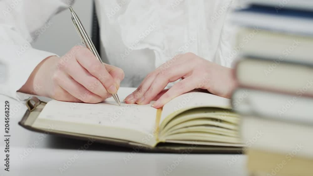 Hands of a woman writing on an agenda Hands of a woman writing on an agenda