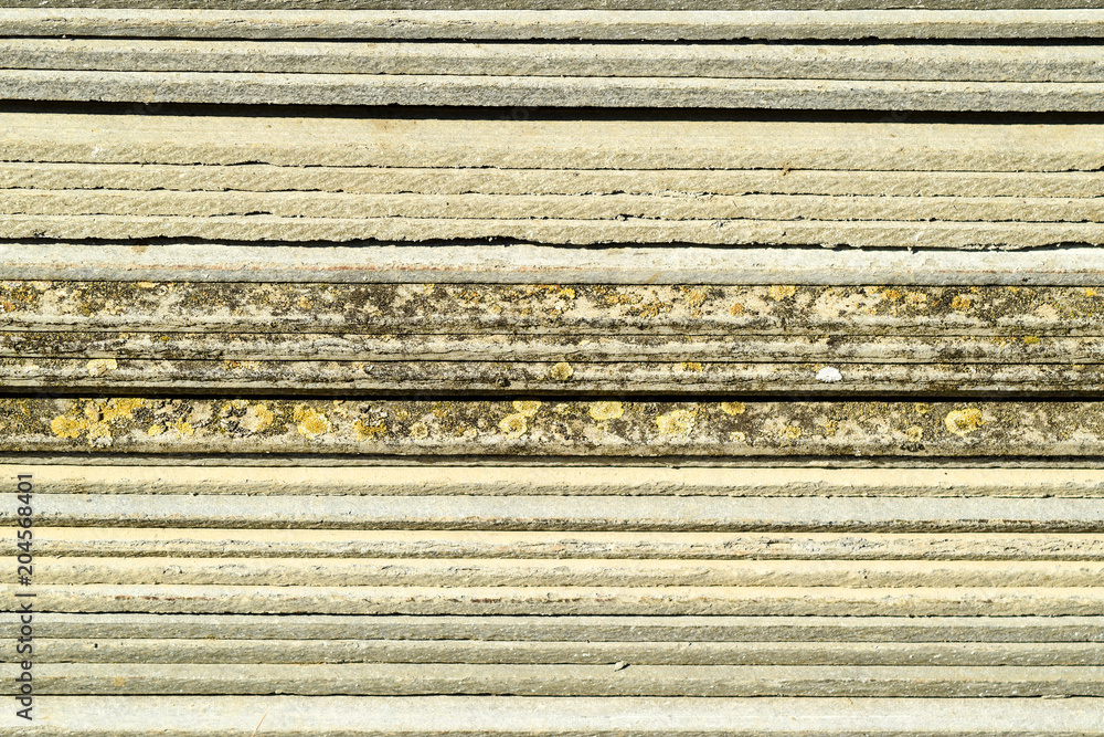 Corrugated slate lies in a pile, side view background texture of slate Corrugated slate lies in a pile, side view background texture of slate