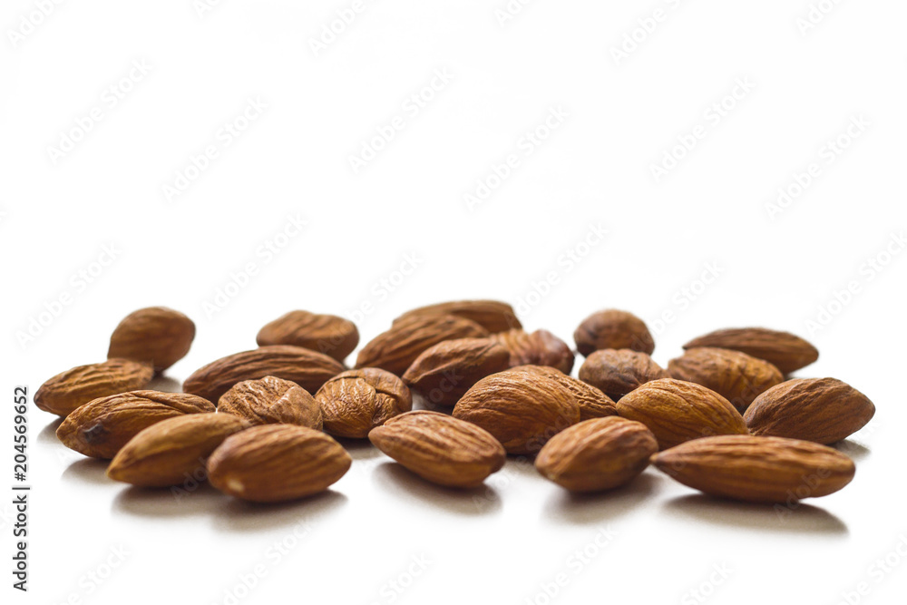 A handful of almonds on the table. Isolated over white background A handful of almonds on the table. Isolated over white background