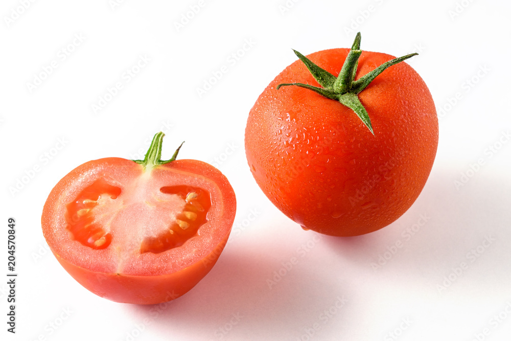 Whole tomato and a half tomato isolated on white. Whole tomato and a half tomato isolated on white.