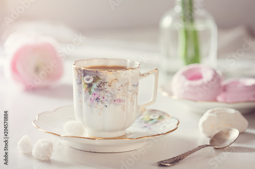 Early morningbreakfast. Vintage cup of coffee and sweets on the table photo