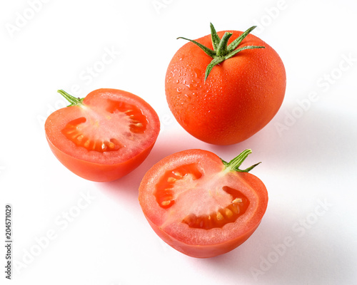 Whole tomato and a half tomato isolated on white.
