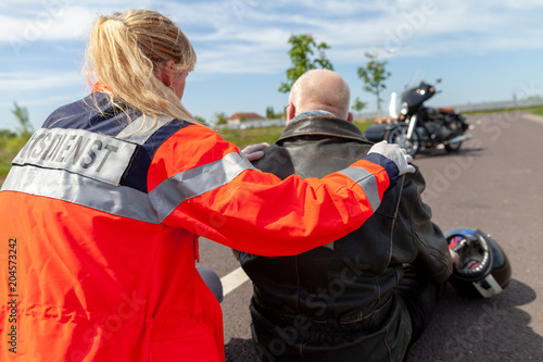A german paramedic helps an injured motorcyclist. Rettungsdienst is the german word for ambulance service.