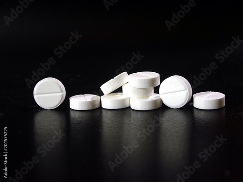 White pills close-up on dark