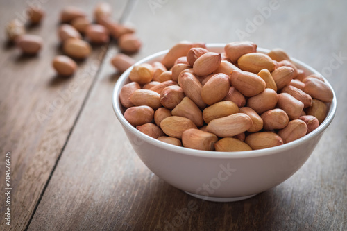 Raw peanuts in white bowl