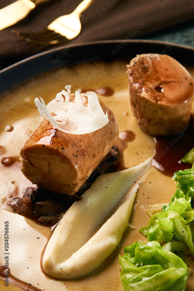 Delicious homemade meat sausage and boiled cabbage with sauce on a plate, close-up. Delicious homemade meat sausage and boiled cabbage with sauce on a plate, close-up.