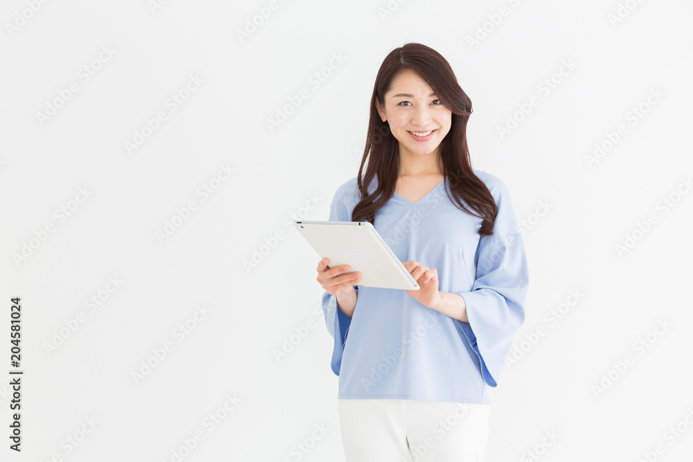 部屋でタブレットを見る女性