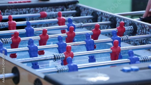 Close up, people play with foosball table
