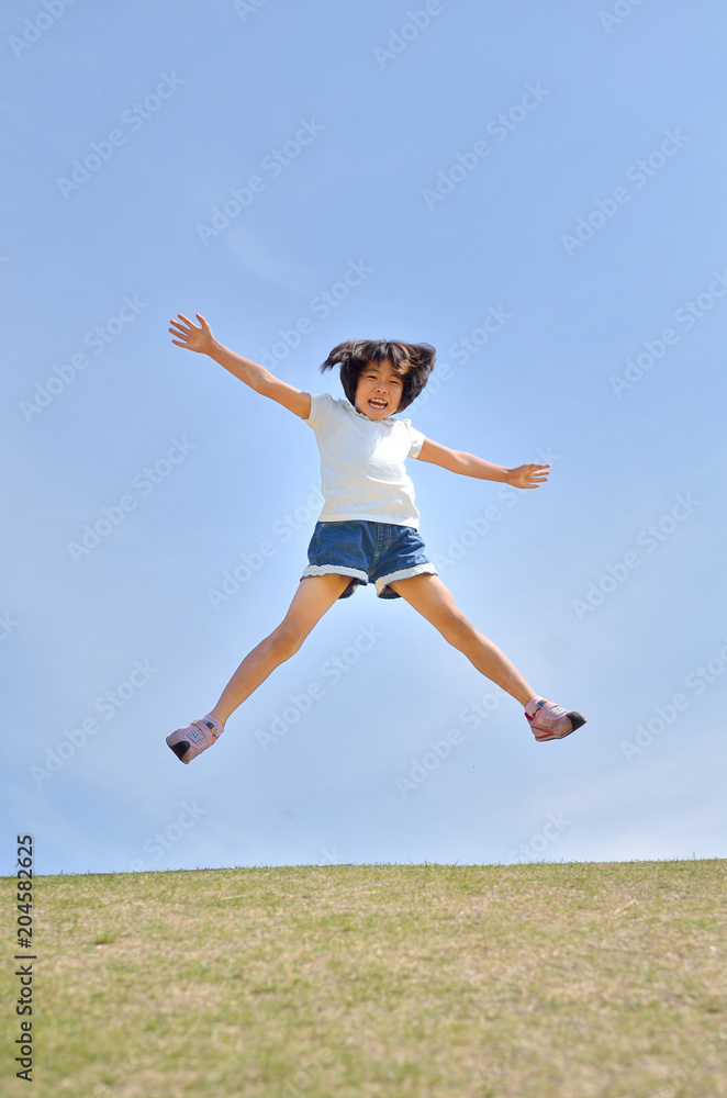 青空でジャンプする女の子