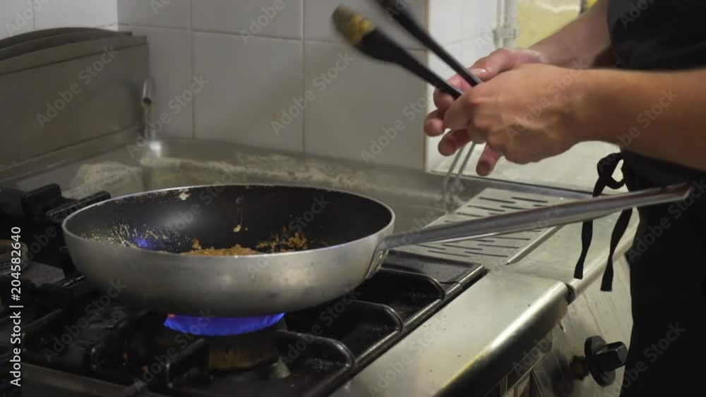 Chef cooks pasta over stovetop, close up Chef cooks pasta over stovetop, close up