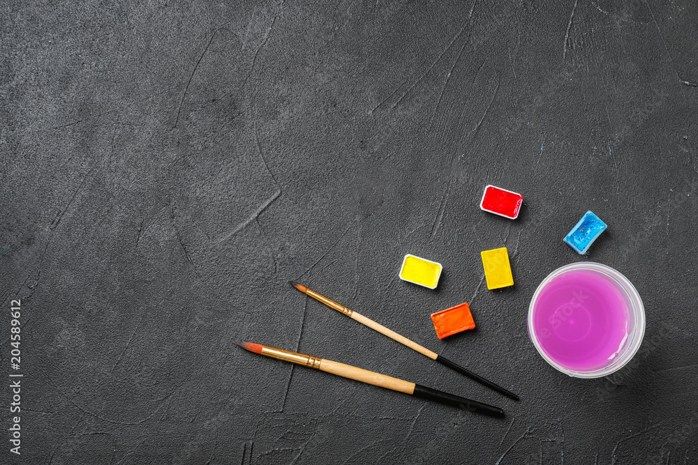 Flat lay composition with different paints and brushes on dark background. Color palette Flat lay composition with different paints and brushes on dark background. Color palette