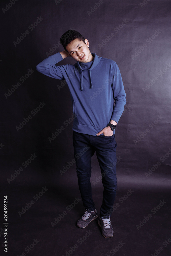 Portrait of a young guy in a blue sweatshirt, reflecting, isolated on a white background