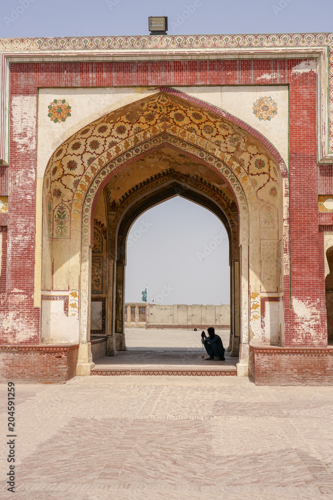 An entrance to Lahore fort with a silhouette of a man sitting , Lahore, Pakistan