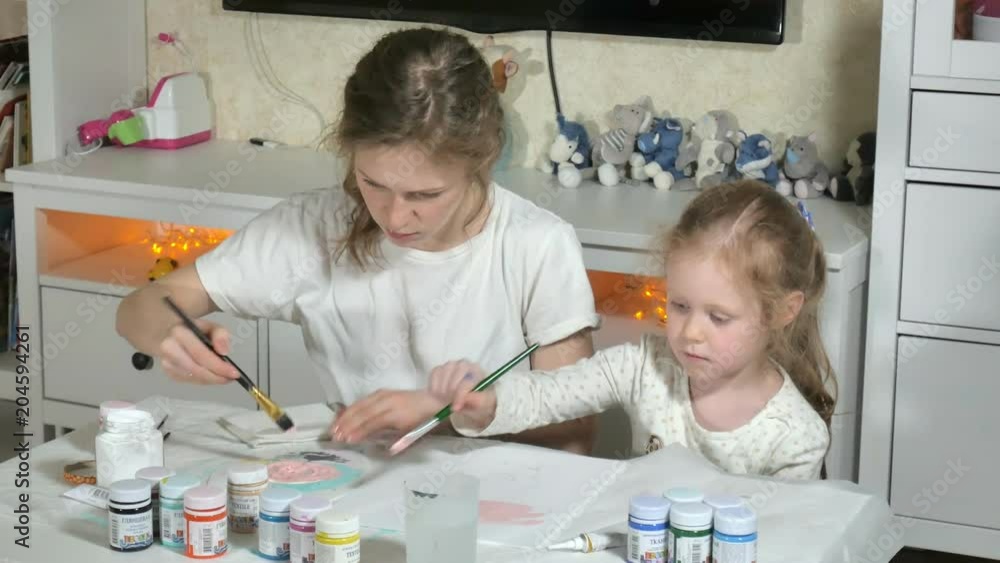 Mother and child paint with colored fingers. Games with children affect the development of early children. Mother and child paint with colored fingers. Games with children affect the development of early children.