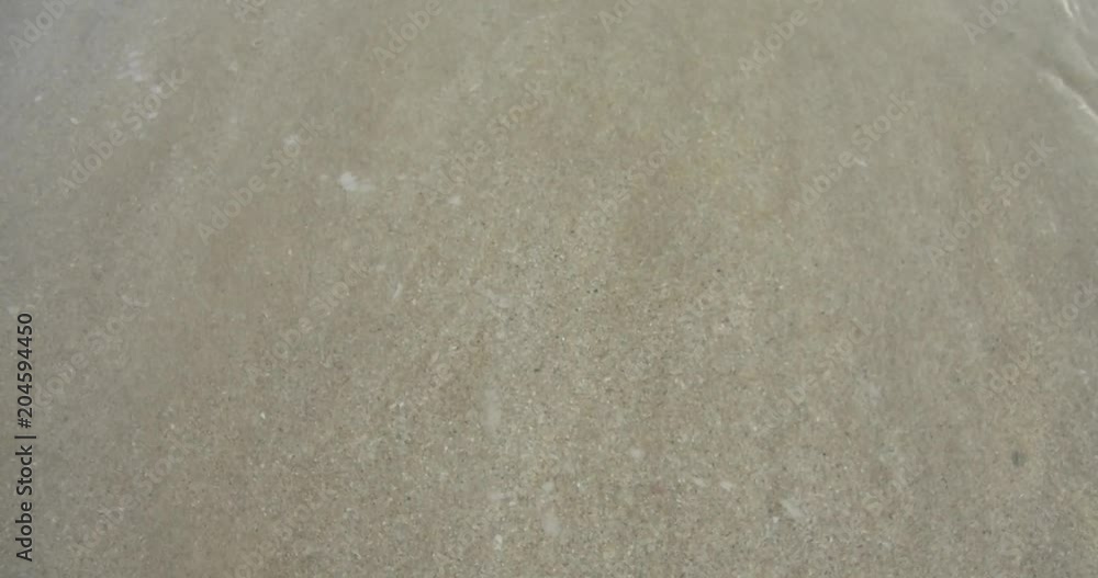 Seawater waves and sand beach Waves gently wash up onto the beach Seawater waves and sand beach Waves gently wash up onto the beach