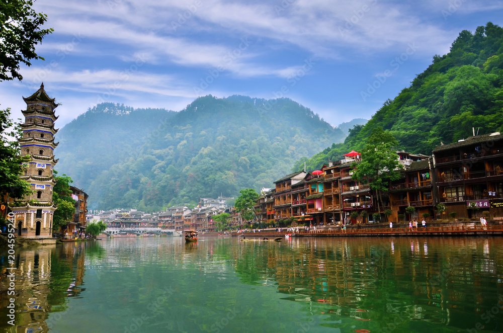 HUNAN, CHINA - JUNE 16, 2014 : Old houses in Fenghuang county in Hunan, China. The ancient town of Fenghuang was added to the UNESCO World Heritage Tentative List in the Cultural category. HUNAN, CHINA - JUNE 16, 2014 : Old houses in Fenghuang county in Hunan, China. The ancient town of Fenghuang was added to the UNESCO World Heritage Tentative List in the Cultural category.