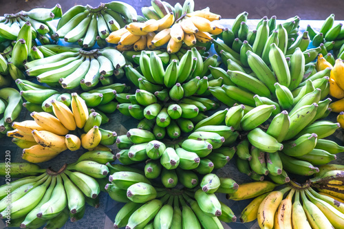 Green and yellow bananas on display for sale at Fugalei fresh produce market, Apia, Samoa photo