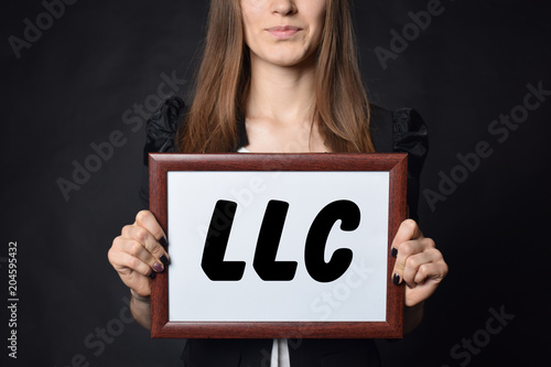 In the hands of a businessman a frame with the inscription:LLC