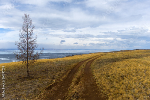 Track winding back roads in the mountains. Dirt road on Olkhon island in lake Baikal. photo