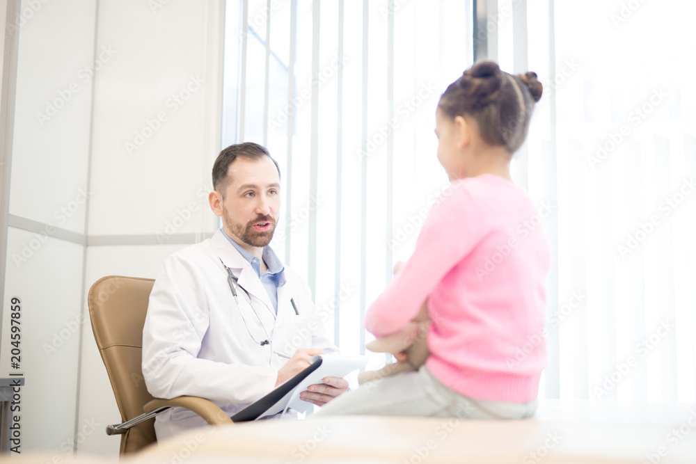 Confident doctor consulting one of his little patients and giving recommendations about medicare Confident doctor consulting one of his little patients and giving recommendations about medicare