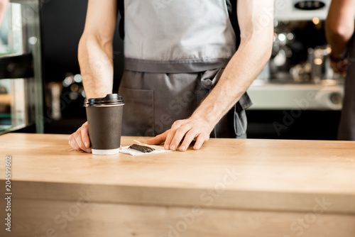 Barista holding coffee cups indoors