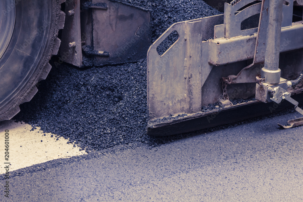 Paver makes the new asphalt on the road