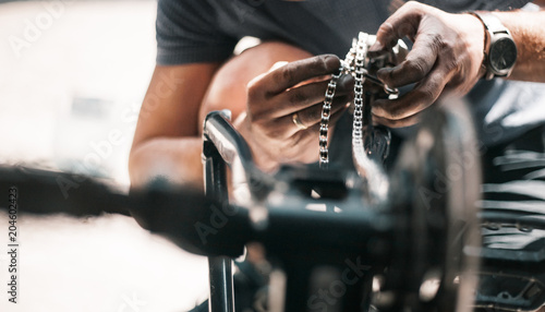 A guy athlete serves and repairs his mountain bike in the garage