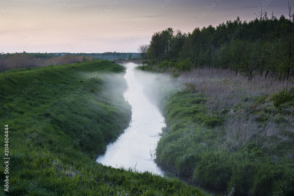 Rising fog over a small river