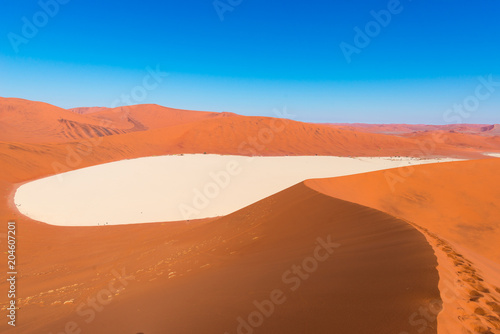 Sossusvlei Namibia, clay and salt pan surrounded by majestic sand dunes. Namib Naukluft National Park, main visitor attraction and travel destination in Namibia.