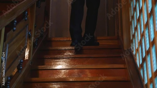 The man in black trousers goes down the stairs