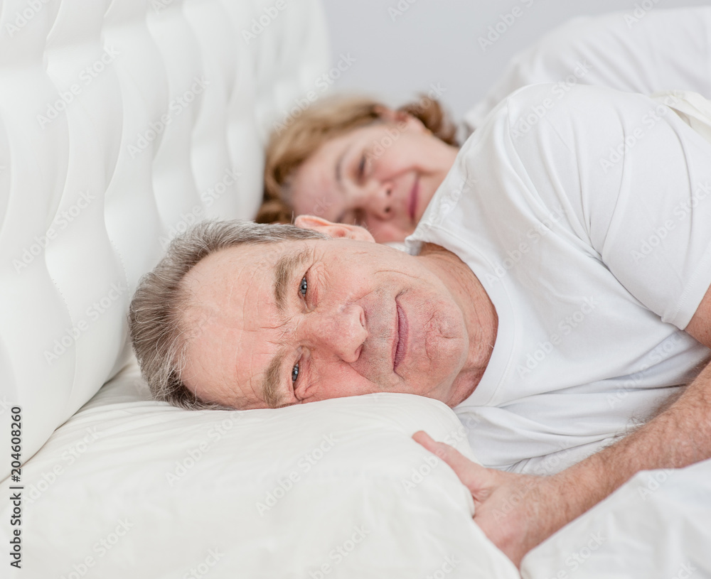 Elderly couple lying together on the bed Elderly couple lying together on the bed