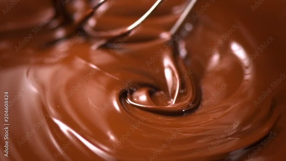 Chocolate. Mixing melted dark chocolate with a whisk. Closeup of liquid hot chocolate swirl. Confectionery. Slow motion 4K UHD video 3840X2160 Chocolate. Mixing melted dark chocolate with a whisk. Closeup of liquid hot chocolate swirl. Confectionery. Slow motion 4K UHD video 3840X2160