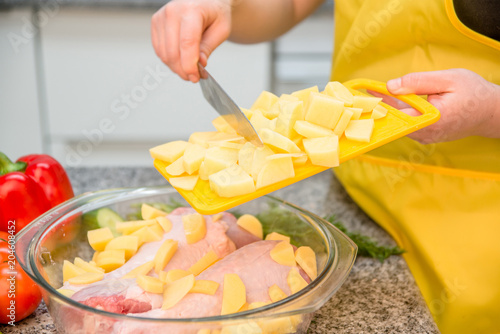 woman in the kitchen preparing turkey meat with potatoes
